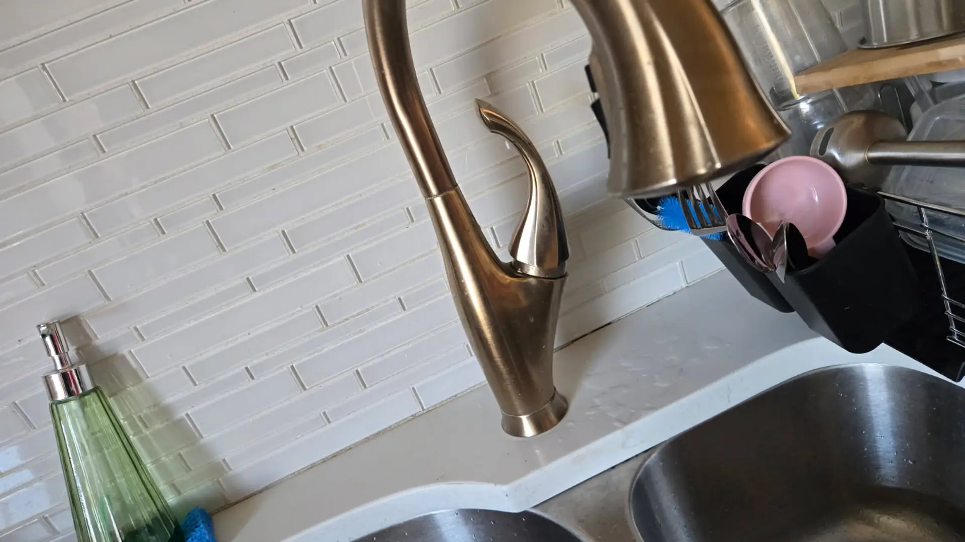 Brushed bronze pull-down kitchen faucet over a stainless double sink