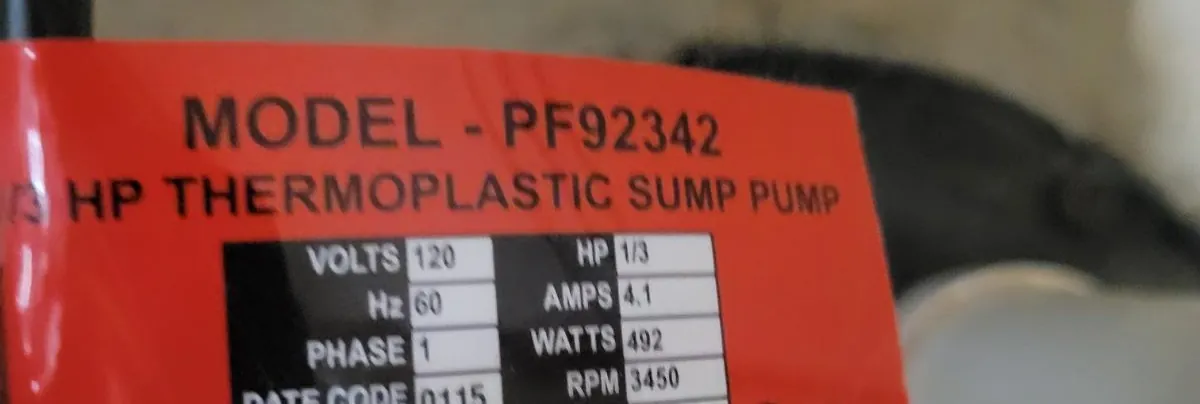 Red rating label on the old 1/3 HP thermoplastic sump pump showing 120 volts, 4.1 amps and a 0115 date code