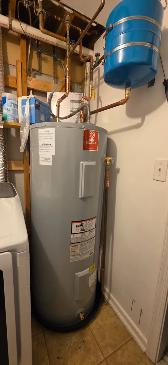 New gray State Select electric water heater in a drip pan with a blue expansion tank on the wall