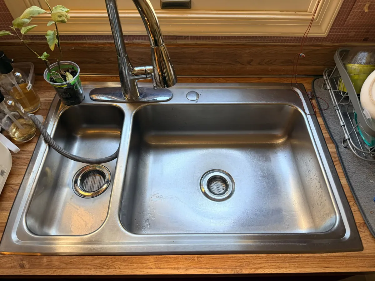 Stainless steel double-bowl kitchen sink with a pull-down faucet